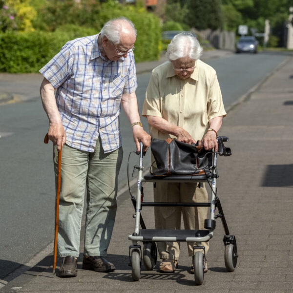 Elderly Couple with Walking Frame and Stick on the Sidewalk